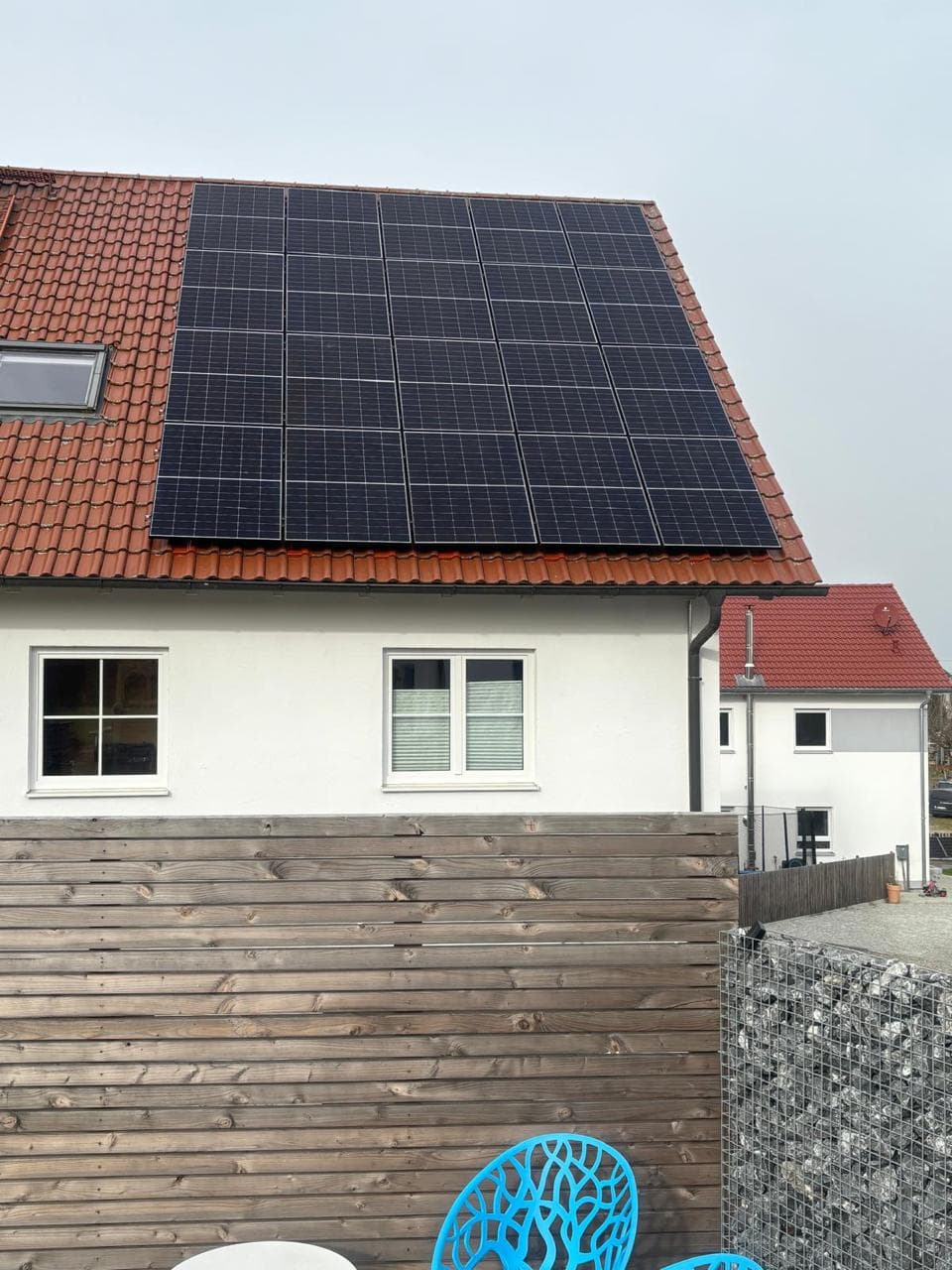 PV-Anlage auf rotem Dach mit Landschaft