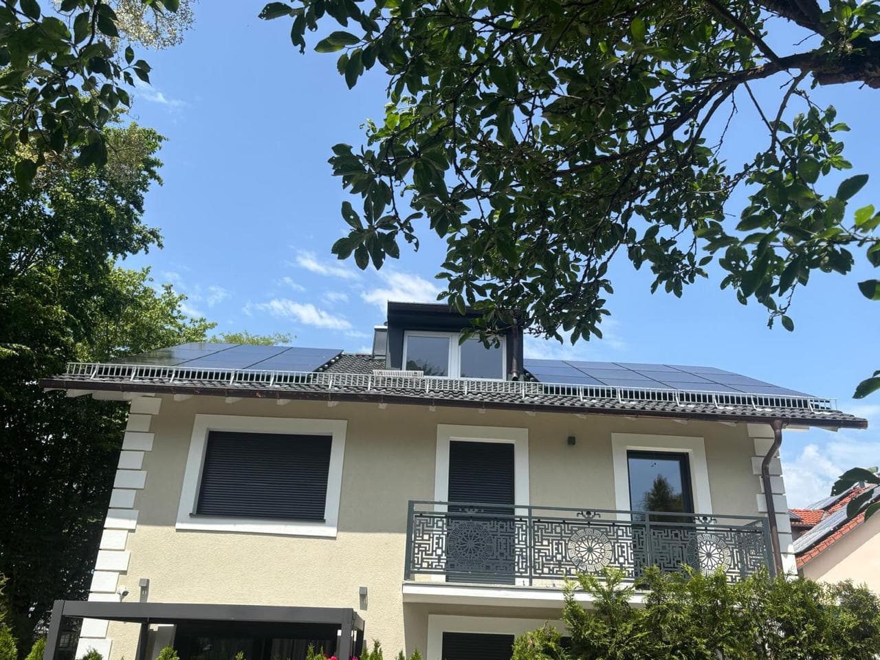 Haus mit PV-Anlage und blauem Himmel